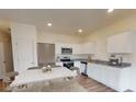 Well-lit kitchen featuring white cabinetry, stainless steel appliances, and a dining area at 3013 Acacia Cir, Douglasville, GA 30135