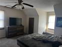 Cozy bedroom featuring neutral walls, a large dresser, and a ceiling fan for added comfort at 7977 Woods Ln, Jonesboro, GA 30236