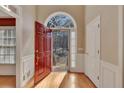 Inviting foyer with a red front door, hardwood floors, and a beautiful transom window for natural light at 2012 Trade Winds Dr, Canton, GA 30115