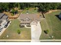 Aerial view of a two-story home with a large backyard, a long driveway, and surrounded by mature trees at 2106 Sycamore Ln, Loganville, GA 30052