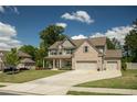 Charming two-story home with a front porch, two-car garage, and a well-kept lawn on a sunny day at 2106 Sycamore Ln, Loganville, GA 30052
