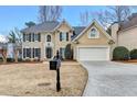 Attractive two-story home featuring a manicured lawn, classic shutters, and a spacious two-car garage at 235 Haydens Walk Ct, Johns Creek, GA 30022
