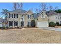 Beautiful two-story home featuring a manicured lawn, classic shutters, and a spacious two-car garage at 235 Haydens Walk Ct, Johns Creek, GA 30022