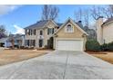 Inviting two-story home featuring a manicured lawn, classic shutters, and a spacious two-car garage at 235 Haydens Walk Ct, Johns Creek, GA 30022