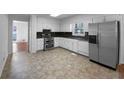 Well-lit kitchen with white cabinetry, stainless steel appliances, and durable flooring, offers a practical and clean cooking space at 8005 Bamby Ln, Jonesboro, GA 30236