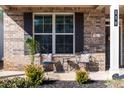 Inviting front porch with seating area, decorative plants, and stylish brickwork and shutters at 116 Holly View Ln, Canton, GA 30114