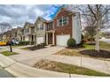 Street view of townhomes featuring attached garages, sidewalks and lush landscaping for curb appeal at 3374 Thornbridge Dr, Powder Springs, GA 30127