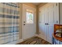Bright bathroom showing the shower with blue striped curtain, wood-look flooring, and a full light door at 885 Malcom Rd, Covington, GA 30014