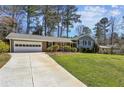 Classic home featuring an attached garage, manicured lawn and complementary landscaping at 860 Valleymeade Se Dr, Marietta, GA 30067