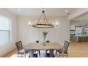 Chic dining room with a modern chandelier, wainscoting and views into the kitchen at 1533 Grayson Pkwy, Grayson, GA 30017