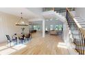 Open-concept living space with hardwood floors, staircase, large windows, and modern chandelier with views to the kitchen at 1533 Grayson Pkwy, Grayson, GA 30017