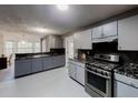 Well lit kitchen features stainless steel oven and range and a large granite topped counterspace at 3068 River Oak Rd, Decatur, GA 30034