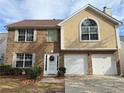 Charming two-story home features a brick facade, attached two-car garage, and well-maintained front yard at 4369 Estate St, South Fulton, GA 30349