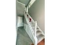 Staircase with a white banister, carpeted steps, and neutral wall color at 4369 Estate St, South Fulton, GA 30349