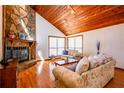 Warm living room with a stone fireplace, wood ceiling, and hardwood floors at 2191 Spear Point Dr, Marietta, GA 30062