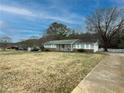 A charming home with green siding, a sprawling lawn, and a long driveway leading to an attached garage at 2056 Merle Se Dr, Conyers, GA 30013