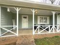 Inviting front porch features white railing, cozy seating, and charming decor for relaxing outdoor enjoyment at 2056 Merle Se Dr, Conyers, GA 30013