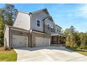 Elegant home with a three-car garage, a mix of gray siding and brick, and a charming front porch at 2460 Hidden Creek Rd, Kennesaw, GA 30152