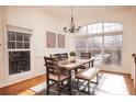 Bright dining room featuring hardwood floors, wainscoting, modern chandelier, and large window at 2661 Rivers Edge Ne Dr, Atlanta, GA 30324