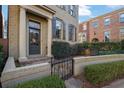 Inviting townhome entrance with classic columns, wrought iron gate, and lush landscaping at 3112 Neal Ct, Cumming, GA 30041