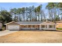Inviting ranch-style home with a covered front porch, garage, and a well-manicured lawn at 405 Cativo Dr Sw, Chattahoochee Hills, GA 30311