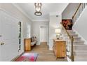 Bright foyer features hardwood floors, staircase, and a charming bench, creating a welcoming entrance at 146 River Ridge Ln, Roswell, GA 30075