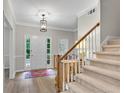 Bright foyer with hardwood floors, staircase, and a charming bench, creating a welcoming entrance at 146 River Ridge Ln, Roswell, GA 30075
