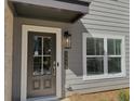 Home exterior featuring a dark front door, modern light fixture, and the house number at 5455 Blossomwood Sw Trl, Mableton, GA 30126