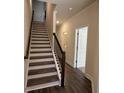 Interior shot of a staircase with modern railings and hardwood floors leading to the upper level at 5455 Blossomwood Sw Trl, Mableton, GA 30126