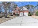 Long driveway leads to a beautiful brick home with a two-car attached garage at 3743 Heathermoor Ct, Dacula, GA 30019
