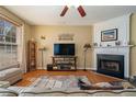 Inviting living room with a fireplace, ceiling fan, neutral walls, and hardwood flooring throughout the home at 4645 Valais Ct # 162, Alpharetta, GA 30022