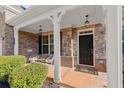 Inviting front porch with stone accents, stylish seating, and charming curb appeal at 485 St Annes Pl, Covington, GA 30016