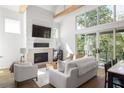 Bright living room featuring a fireplace, high ceilings, and abundant natural light at 1290 Lupo Loop, Chattahoochee Hills, GA 30268