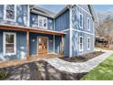Inviting blue two-story home boasts a charming front porch and manicured landscaping at 474 Maxwell Rd, Roswell, GA 30075
