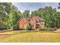 Traditional brick home with a manicured lawn and mature trees at 1290 Regency Center Sw Dr, Atlanta, GA 30331