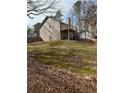 A spacious backyard featuring a deck, mature trees, a partial fence line and a large grassy area at 4155 Gables Pl, Buford, GA 30519