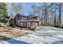 Spacious brick home with a large driveway and ample parking space, surrounded by lush greenery at 5180 Cameron Forest Pkwy, Johns Creek, GA 30022