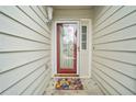 Close-up of the front door with a decorative glass insert and a welcoming floral doormat at 2323 River Station Ter, Woodstock, GA 30188