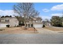 Suburban two-story home with beige siding, a two-car garage, well-manicured lawn, and mature trees in a Gathering-friendly neighborhood at 939 Mill Creek Ave, Canton, GA 30115