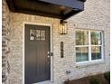 Close-up of a stylish front door with sleek hardware, and a brick facade at 5447 Blossomwood Sw Trl, Mableton, GA 30126