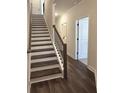 Elegant hallway with hardwood floors, staircase and white trim, leading to the main areas of the home at 5447 Blossomwood Sw Trl, Mableton, GA 30126