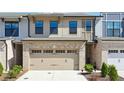 Two-story townhome with brick accents, a two-car garage, and manicured landscaping at 599 Collections Dr, Lawrenceville, GA 30043