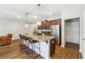 Open concept kitchen with an island, granite countertops, seating, and modern stainless steel appliances at 599 Collections Dr, Lawrenceville, GA 30043