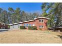 Beautifully updated brick house with a lush green lawn and mature trees offering shade at 3035 Mclendon Nw Cir, Atlanta, GA 30318