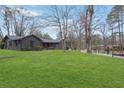 Well-maintained home featuring dark exterior brick, mature trees, and a sprawling green front lawn at 3280 Hazelwood Sw Dr, Atlanta, GA 30311