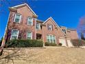 Two story brick home with three-car garage, gabled roof, and manicured lawn at 5066 Healey Dr, Smyrna, GA 30082