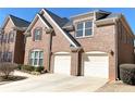 Attached three-car garage on a two-story brick home with well-manicured landscaping at 5066 Healey Dr, Smyrna, GA 30082