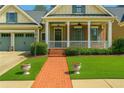 Inviting front yard featuring a brick walkway leading to a charming home with a covered porch at 730 Jackson Miller Cir, Powder Springs, GA 30127
