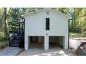 Two-car garage on a home with black trimmed doors and a narrow vertical window at 2450 Spring Mill Cv, Duluth, GA 30097
