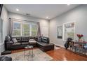 Spacious living room with hardwood floors, a large window, and a comfortable leather sectional at 490 Rockwell Sw St, Atlanta, GA 30310